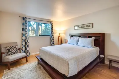a bedroom with a bed and a chair and a window at Hot Tub Access Condo 2 Mi to Winter Park Resort! in Winter Park