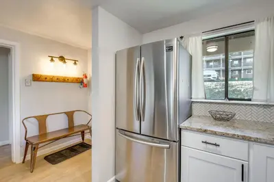 a kitchen with a stainless steel refrigerator and a chair at Hot Tub Access Condo 2 Mi to Winter Park Resort! in Winter Park