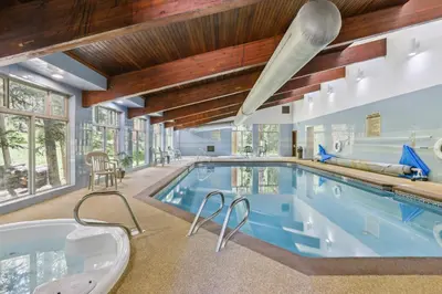 an indoor pool in a house with a tub at Hot Tub Access Condo 2 Mi to Winter Park Resort! in Winter Park