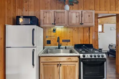 a kitchen with a white refrigerator and a sink at Cabin 1- Hot Tub Grill- Mins to RMNP in Estes Park