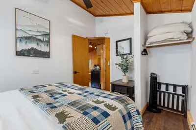 a bedroom with a bed and a wooden ceiling at Cabin 1- Hot Tub Grill- Mins to RMNP in Estes Park