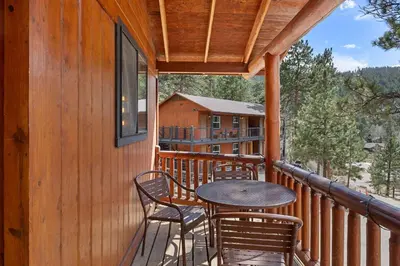 a balcony with a table and chairs on a cabin at Cabin 1- Hot Tub Grill- Mins to RMNP in Estes Park