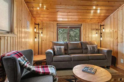 a living room with a couch and a table at Cabin 1- Hot Tub Grill- Mins to RMNP in Estes Park