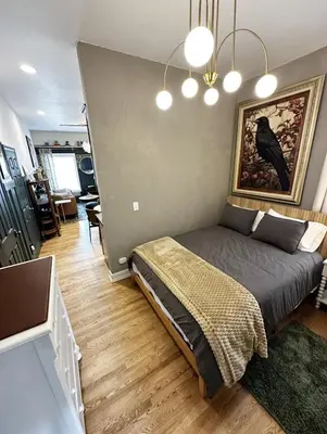 a bedroom with a bed with a painting on the wall at RiNo Retreat Flat walkable and great location in Denver