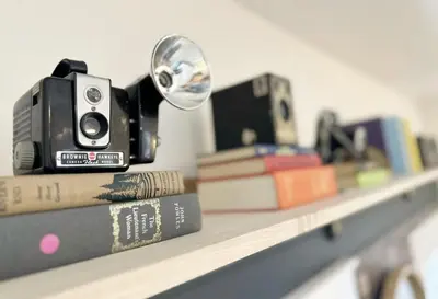 a camera sitting on a shelf with books at RiNo Retreat Flat walkable and great location in Denver