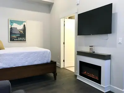 a bedroom with a bed and a fireplace at Steps to Lake Fireplace Indoor Outdoor Oasis in Grand Lake