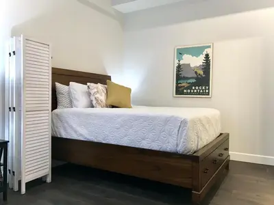 a bedroom with a bed and a picture on the wall at Steps to Lake Fireplace Indoor Outdoor Oasis in Grand Lake