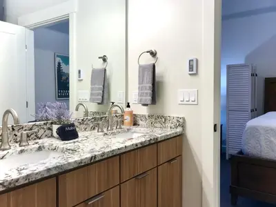 a bathroom with a sink and a large mirror at Steps to Lake Fireplace Indoor Outdoor Oasis in Grand Lake