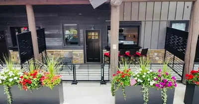 a restaurant with flowers in pots on the front porch at Steps to Lake Fireplace Indoor Outdoor Oasis in Grand Lake