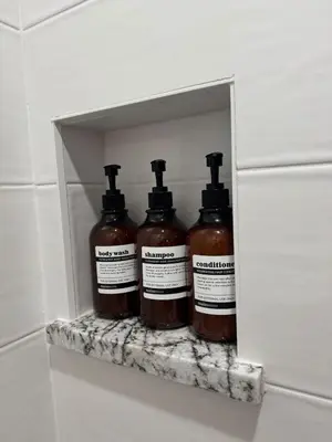 four bottles of honey sitting on a shelf in a bathroom at Steps to Lake Fireplace Indoor Outdoor Oasis in Grand Lake