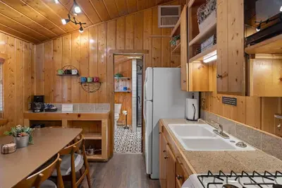 a kitchen with a white refrigerator and a sink at Cabin 2- Two BR Cabin w Hot Tub in Estes Park