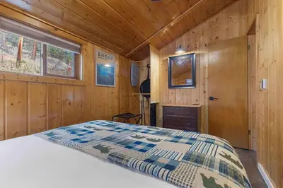 a bedroom with a bed in a wooden cabin at Cabin 2- Two BR Cabin w Hot Tub in Estes Park