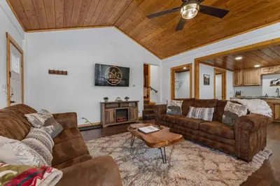 a living room with two couches and a fireplace at Cabin 3- Cozy updated cabin 5 min to RMNP in Estes Park