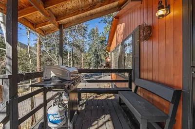 a grill on the porch of a cabin at Cabin 3- Cozy updated cabin 5 min to RMNP in Estes Park