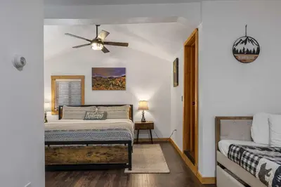 a bedroom with a bed and a ceiling fan at Cabin 3- Cozy updated cabin 5 min to RMNP in Estes Park