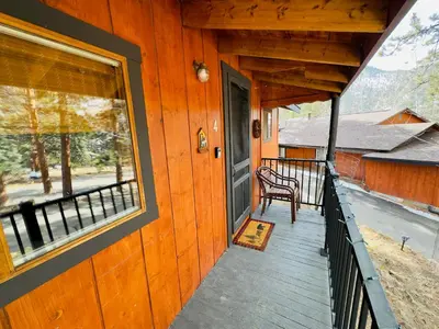 a porch of a cabin with a chair and a window at Cabin 4- One Bedroom cabin- RMNP in Estes Park