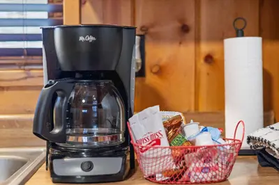 a coffee maker on a counter next to a basket of food at Cabin 4- One Bedroom cabin- RMNP in Estes Park