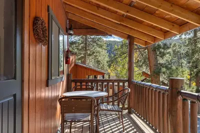 a porch with two chairs and a table on it at Cabin 5- Private Cabin w King bed kitchen porch in Estes Park