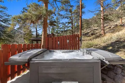 a hot tub in front of a wooden fence at Cabin 6- Private Hot Tub 5 Min to RMNP in Estes Park