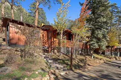 a house in the woods with a fence at Cabin 6- Private Hot Tub 5 Min to RMNP in Estes Park