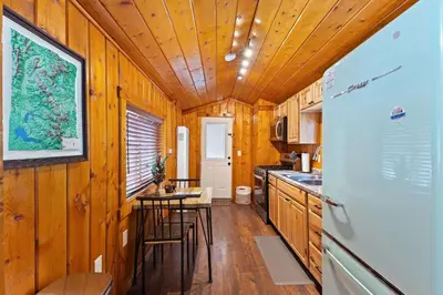 a kitchen with a refrigerator and a table and chairs at Cabin 6- Private Hot Tub 5 Min to RMNP in Estes Park