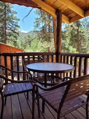 a table and chairs on the deck of a cabin at Cabin 7- Studio Cabin Heated Floors 5 Min to RMNP in Estes Park