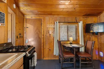 a kitchen with a stove and a table in a cabin at Cabin 7- Studio Cabin Heated Floors 5 Min to RMNP in Estes Park