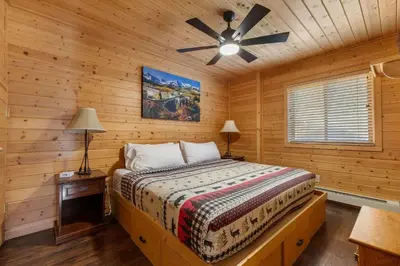 a bedroom with a bed and a ceiling fan at Cabin 9- Spacious cabin- 4 King beds- 2 baths in Estes Park