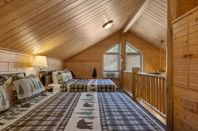 a bedroom with two beds in a log cabin at Cabin 9- Spacious cabin- 4 King beds- 2 baths in Estes Park