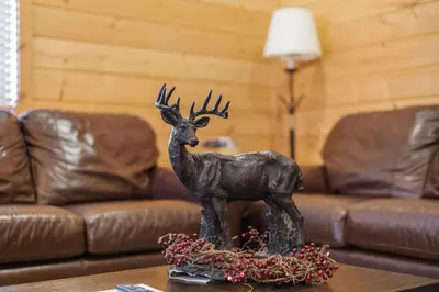 a statue of a deer on a table in a living room at Cabin 9- Spacious cabin- 4 King beds- 2 baths in Estes Park