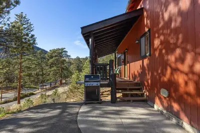 a building with a grill on the side of it at Cabin 9- Spacious cabin- 4 King beds- 2 baths in Estes Park