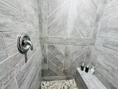 a bathroom with a shower with a stone wall at Cabin 10- King Cabin Mins to RMNP in Estes Park