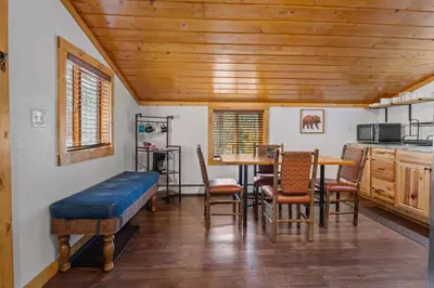 a room with a table and chairs and a kitchen at Cabin 10- King Cabin Mins to RMNP in Estes Park