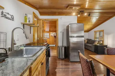 a kitchen with a stainless steel refrigerator in a room at Cabin 10- King Cabin Mins to RMNP in Estes Park