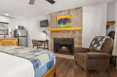 a bedroom with a bed and a fireplace at Cabin 14 - King Bed hotel-style unit in Estes Park