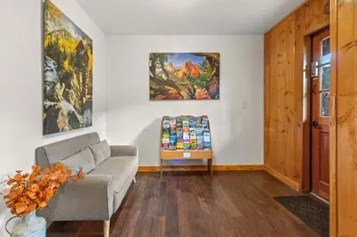 a living room with a couch and paintings on the wall at Cabin 14 - King Bed hotel-style unit in Estes Park