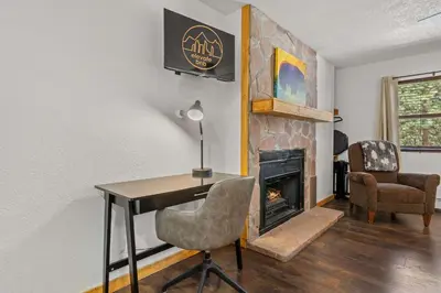 a room with a desk and a fireplace at Cabin 14 - King Bed hotel-style unit in Estes Park