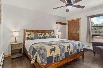 a bedroom with a bed with a quilt with animals on it at Cabin15 - King bed Hotel Style Unit in Estes Park