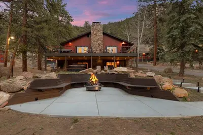 a house with a fire pit in front of it at Cabin15 - King bed Hotel Style Unit in Estes Park