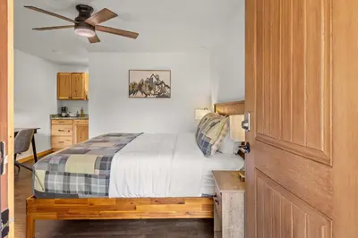 a bedroom with a bed and a ceiling fan at Cabin15 - King bed Hotel Style Unit in Estes Park