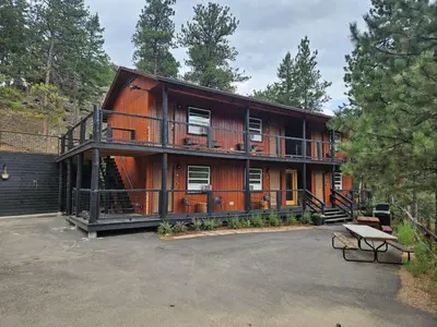 a large wooden house with a balcony and a parking lot at Cabin16 - King Bed Kitchenette & Bath in Estes Park