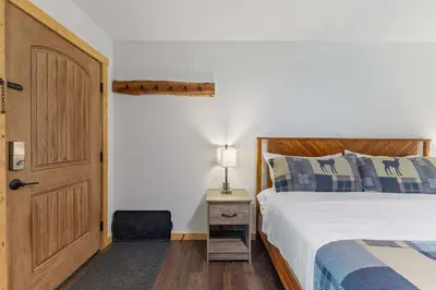 a bedroom with a bed and a door and a chair at Cabin16 - King Bed Kitchenette & Bath in Estes Park
