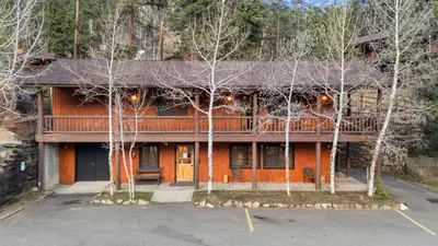 an orange house with trees in front of it at Cabin 17 - King Bed New Kitchen & Bath in Estes Park