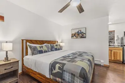 a bedroom with a bed and a ceiling fan at Cabin 17 - King Bed New Kitchen & Bath in Estes Park
