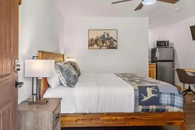a bedroom with a bed and a table with a lamp at Cabin 17 - King Bed New Kitchen & Bath in Estes Park