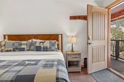 a bedroom with a bed and a door to a balcony at Cabin 18 - King Bed Mountain views Hotel Style in Estes Park