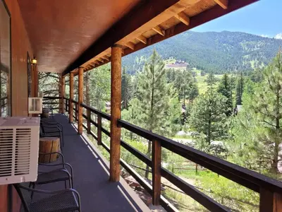 a balcony with chairs and a view of the mountains at Cabin 18 - King Bed Mountain views Hotel Style in Estes Park