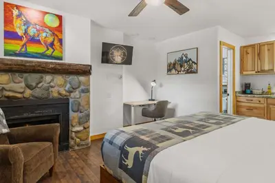 a bedroom with a bed and a fireplace at Cabin 18 - King Bed Mountain views Hotel Style in Estes Park