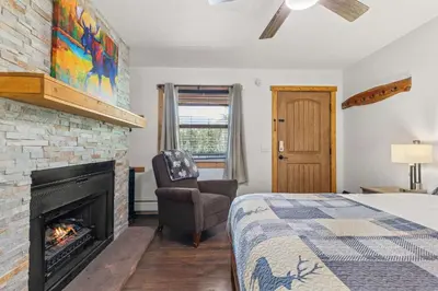 a bedroom with a bed and a fireplace at Cabin 19- King Studio Gorgeous views Hotel Style in Estes Park