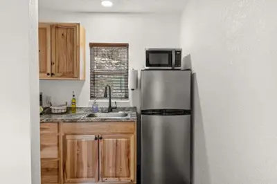 a kitchen with a stainless steel refrigerator and a microwave at Cabin 19- King Studio Gorgeous views Hotel Style in Estes Park